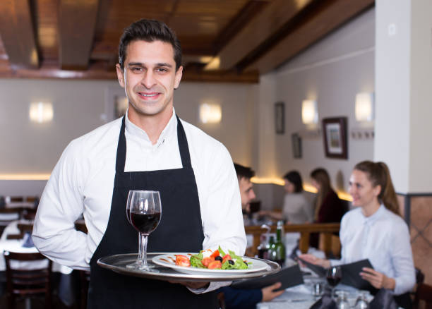 istock Smiling waiter with serving tray 1133527394