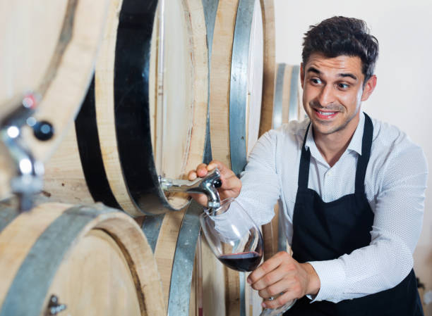 istock Man pouring red wine into glass in alcohol section 1133527434