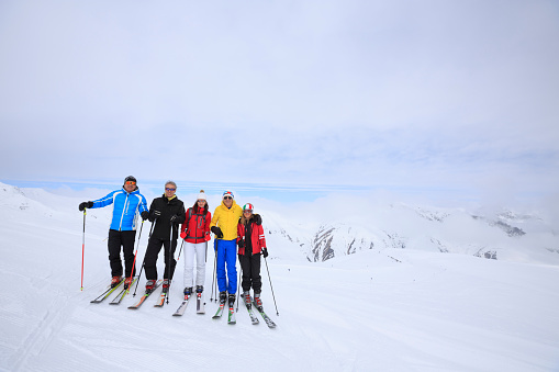 Amateur Winter Sports  alpine skiing. Group of skiers. Best friends men and women, snow skiers, enjoying  skiing.  High mountain snowy landscape. Livigno mountain range, Alps. It is located in the Italiy.