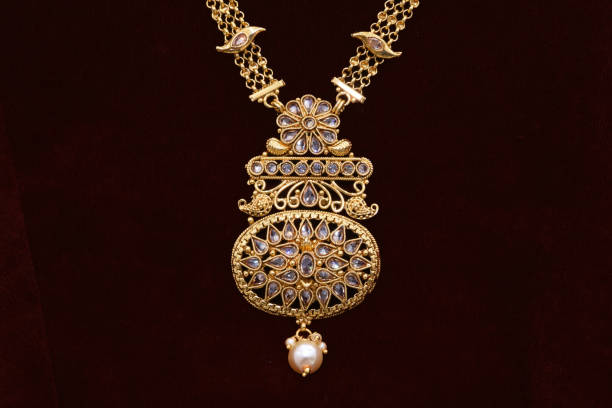 istock Fancy designer golden neckset closeup macro image on red background. 1133527920
