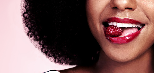 Cropped shot of an unrecognizable woman posing with a cherry in her mouth