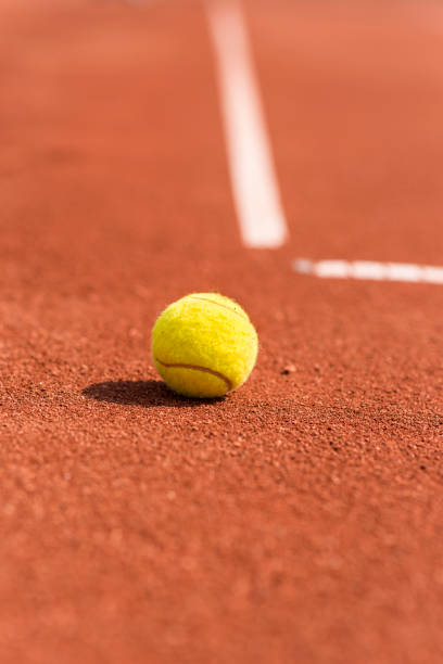 Lonely tennis ball on a sand tennis court