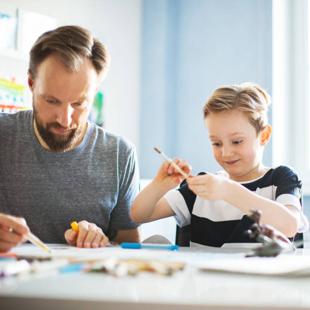istock Father and son painting together 1133530249