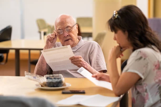 senior asian man y mujer madura revisando documentos financieros juntos - fine print fotografías e imágenes de stock