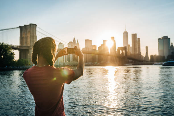 afro-caraibico, turista ispanico a new york, scatta foto di manhattan al tramonto - new york city skyline new york state freedom foto e immagini stock