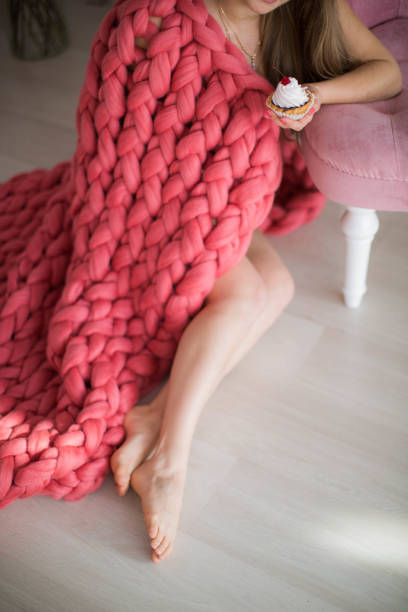 istock Woman covered in pink plaid with cupcake 1133532118