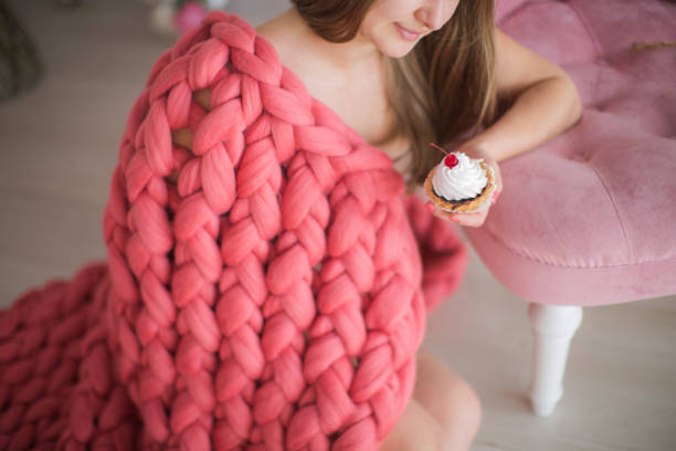 istock Woman covered in pink plaid with cupcake 1133532159