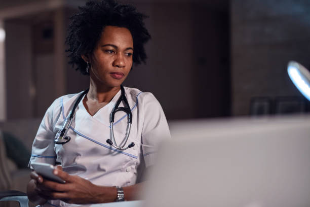 istock Thoughtful African American female doctor using smart phone. 1133533487