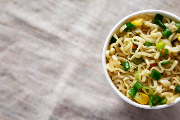 istock Overhead view, prepared instant noodles with beef flavoring in a cup. Flat lay, from above, overhead. Copy space. 1133535175