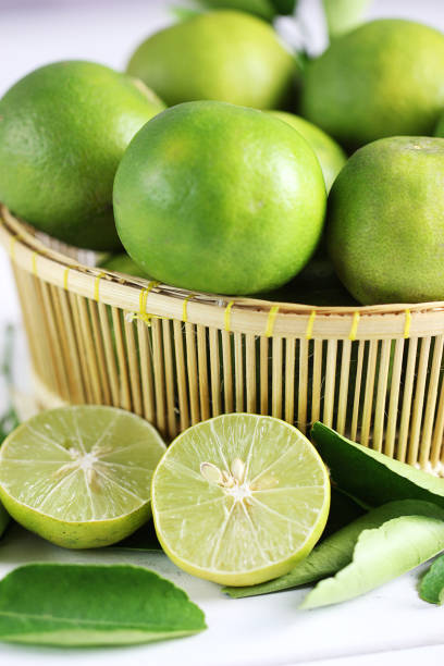istock Fresh limes on white wooden background. Green limes. 1133536064