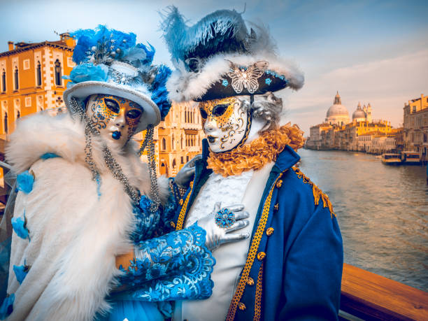 пара человек в маске вдоль большого канала во время венецианского карнавала - venice italy beautiful accademia bridge grand canal стоковые фото и изображения