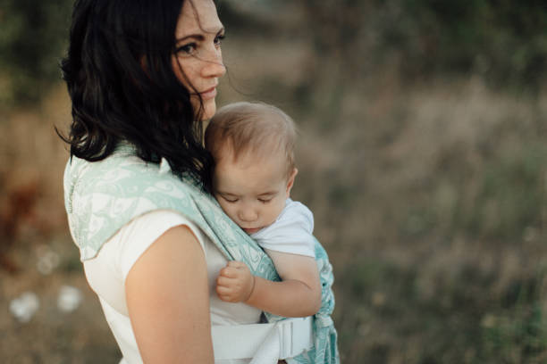 Mother wearing her sleeping child in carrier.