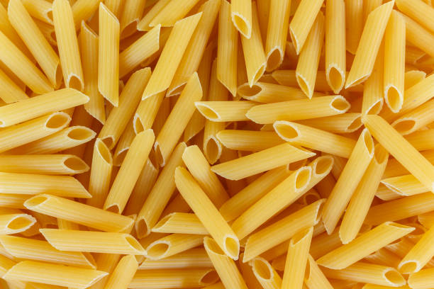 istock dry pasta penne Italian food texture background. 1133541116