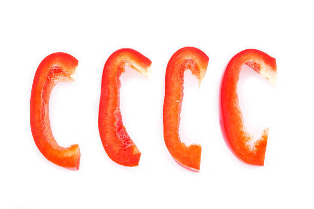 red bell pepper cut into pieces on white background.