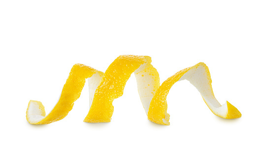 Yellow ripe citrus lemon peel in spiral shape isolated on white background, close-up
