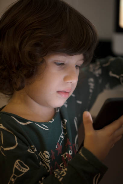 istock Sleepy Little boy on the sofa watching something on mobile 1133543532