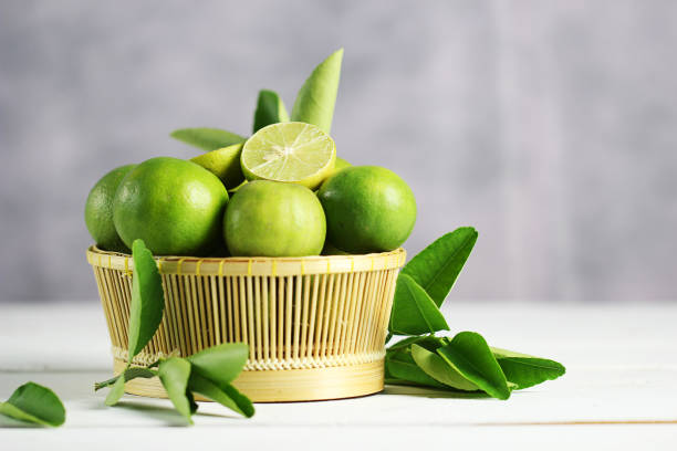 istock Fresh limes on white wooden background. Green limes. 1133544065
