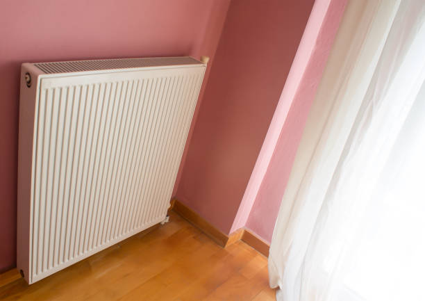 istock Modern radiator on color wall indoors. Central heating system 1133544286