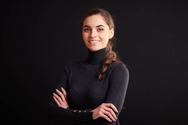 istock Attractive young woman studio portrait while standing at dark background 1133547196