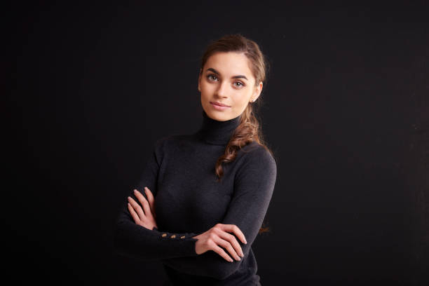istock Attractive young woman studio portrait while standing at dark background 1133547198