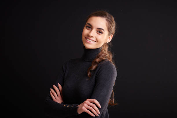 istock Attractive young woman studio portrait while standing at dark background 1133547204