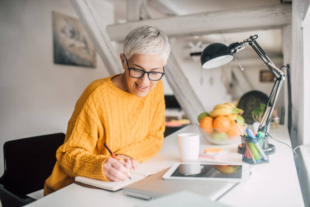 istock Woman writing at home office 1133548216