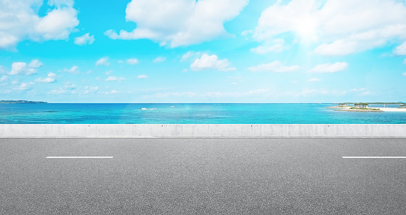 Business and design concept - empty asphalt road with panoramic sea and sky view under bright blue sky for mockup