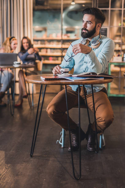 istock Adult male student drinking coffee in library. 1133548671