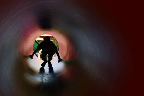 boy silhouette in the pipe - espaço confinado imagens e fotografias de stock