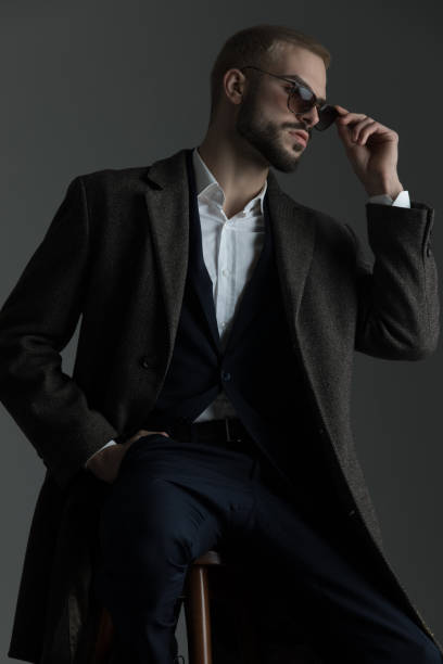 istock man fixing his sunglasses sitting on a stool 1133548803
