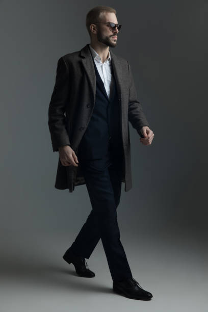 istock blonde man in suit walking 1133549723