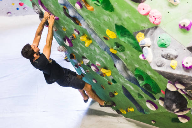 istock Man practicing rock climbing on artificial wall indoors. Active lifestyle and bouldering concept. 1133550259