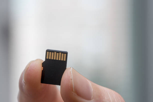 istock Young man is holding a tiny memory card in his hand, text space 1133551795