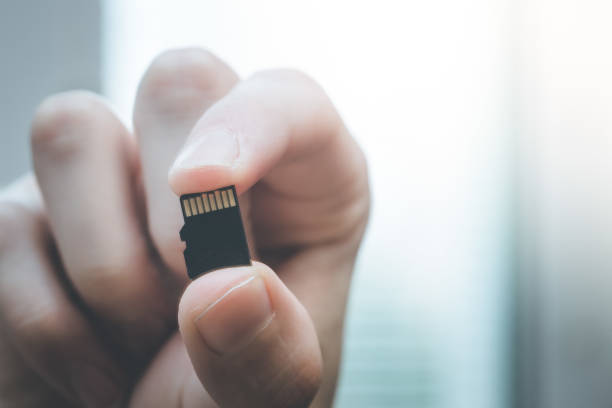 istock Young man is holding a tiny memory card in his hand, text space 1133551847