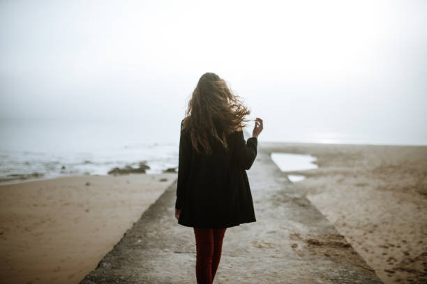 Rear view of a young woman in a pier stock photo