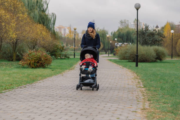 istock A woman walks in the park with a stroller and a small child 1133553733