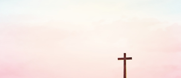 Wooden cross over abstract sky background. Christian concept