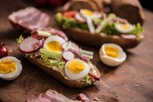 istock Baguette sandwich fresh vegetable dressing bacon panchetta tomatoes eggs and onion. Healthy nutrition breakfast or appetizer. 1133555028