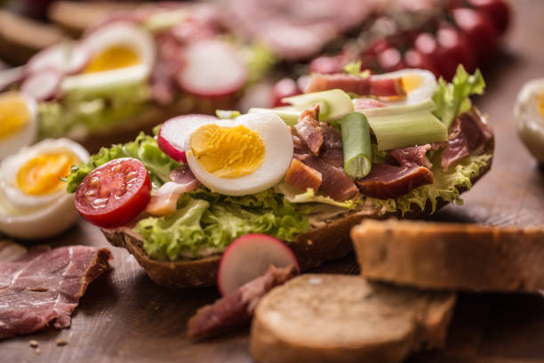 istock Baguette sandwich fresh vegetable dressing bacon panchetta tomatoes eggs and onion. Healthy nutrition breakfast or appetizer. 1133555033