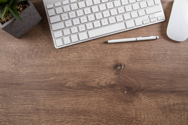 istock Office Desk with Computer Keyboard Plant and A Pen 1133558209