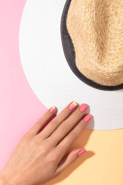 Woman's hands with beautiful manicure holding straw hat isolated on backgrounds