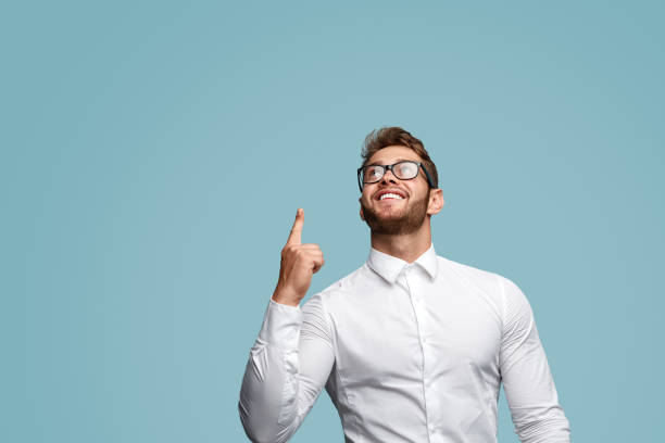 istock Smiling muscular man pointing up 1133562852
