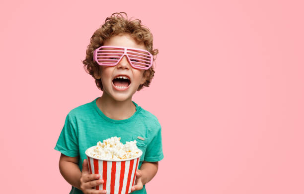 krzyczący chłopiec w okularach trzymający popcorn - glasses child little boys happiness zdjęcia i obrazy z banku zdjęć