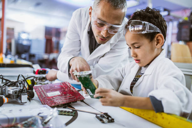 istock African American boy and his teacher working on computer part in laboratory. 1133564728