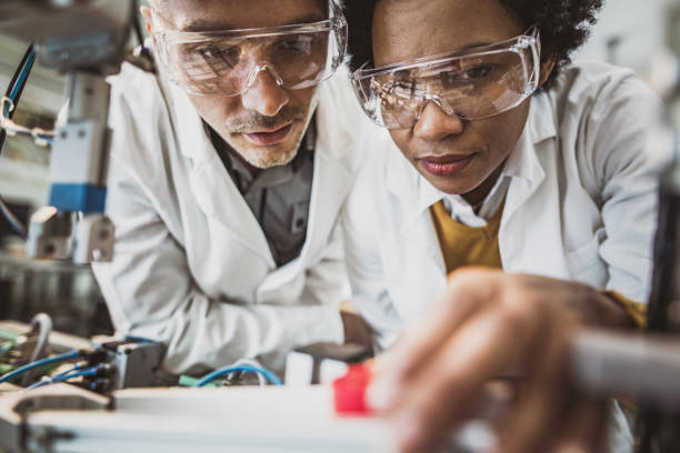 istock Below view of experienced engineers cooperating while working on machinery in laboratory. 1133565154