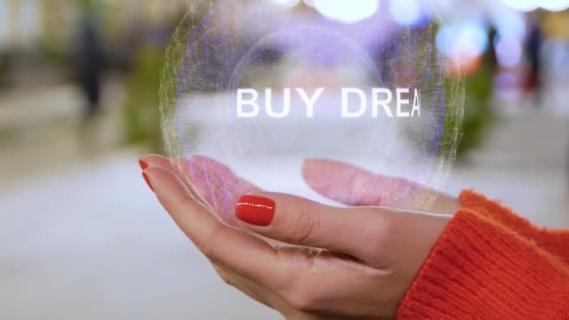 Female hands holding a conceptual hologram Buy dream