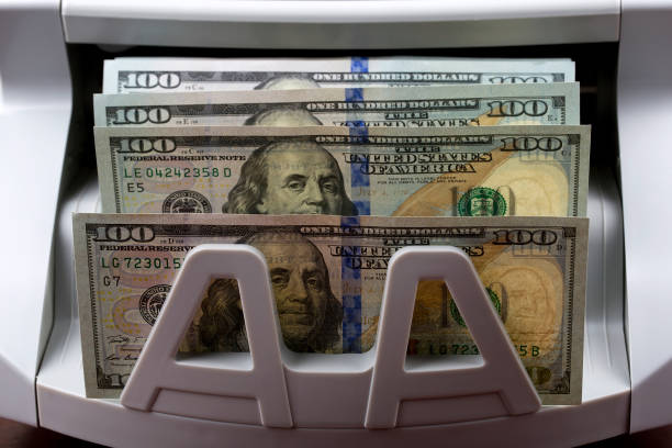 American dollars in a counting machine American money - dollars in a counting machine bank counter stock pictures, royalty-free photos & images