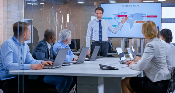 istock Businessman holding a presentation using display in glass conference room 1133565360