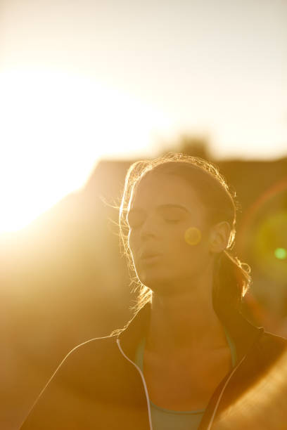 Shot of a sporty young woman taking a break while exercising outdoors