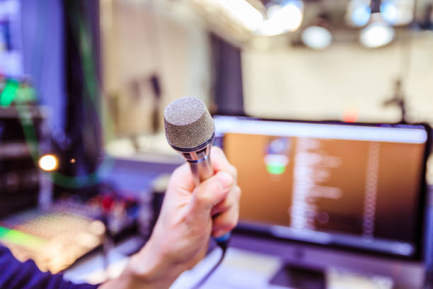 istock Studio recording: Young man speaks into a microphone, studio in the blurry background 1133566819